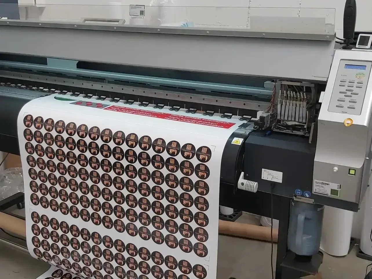 Großformatdrucker mit frisch gedruckten runden Aufklebern