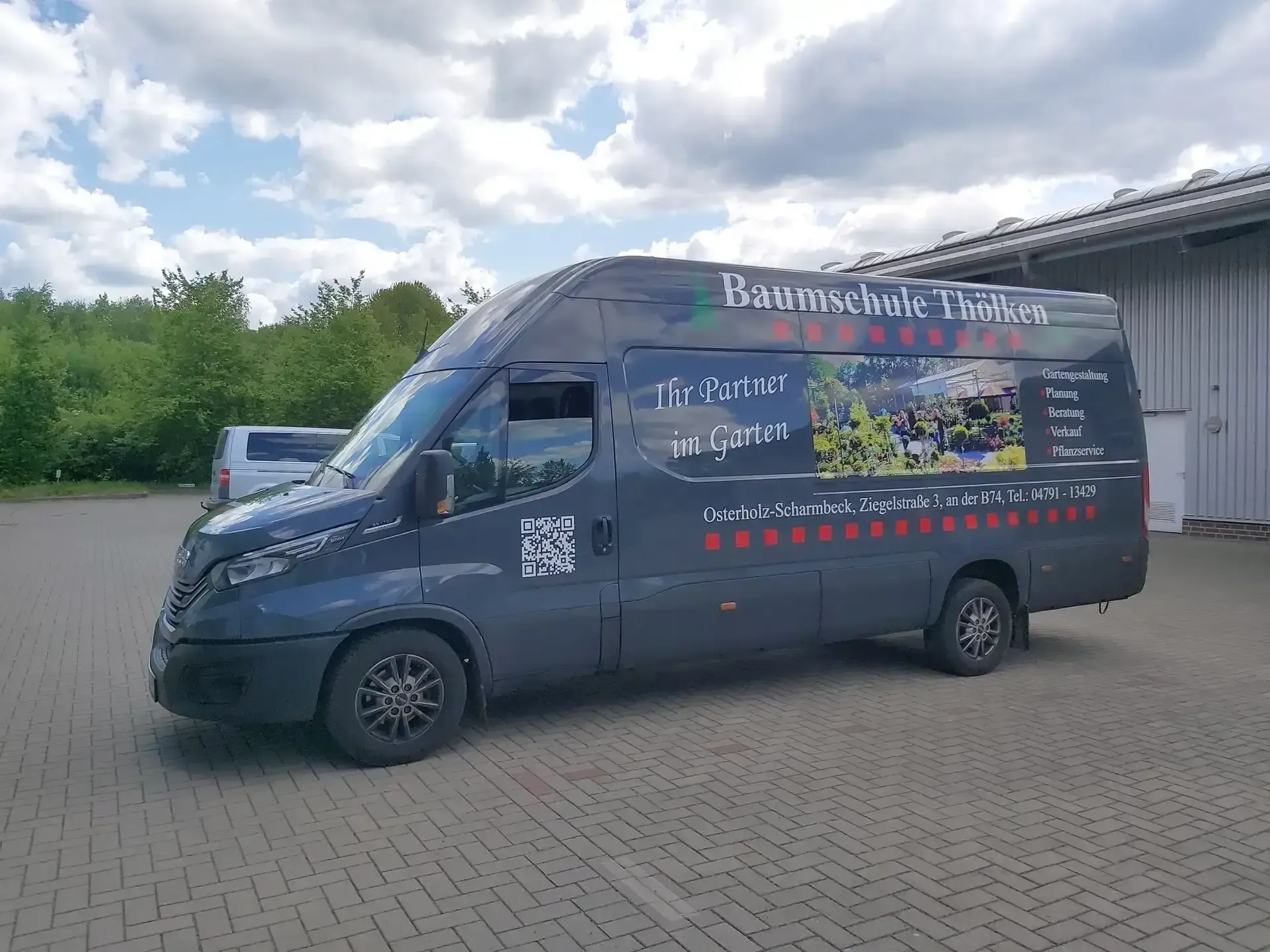 Blauer Transporter mit großflächiger Gestaltung für eine Baumschule