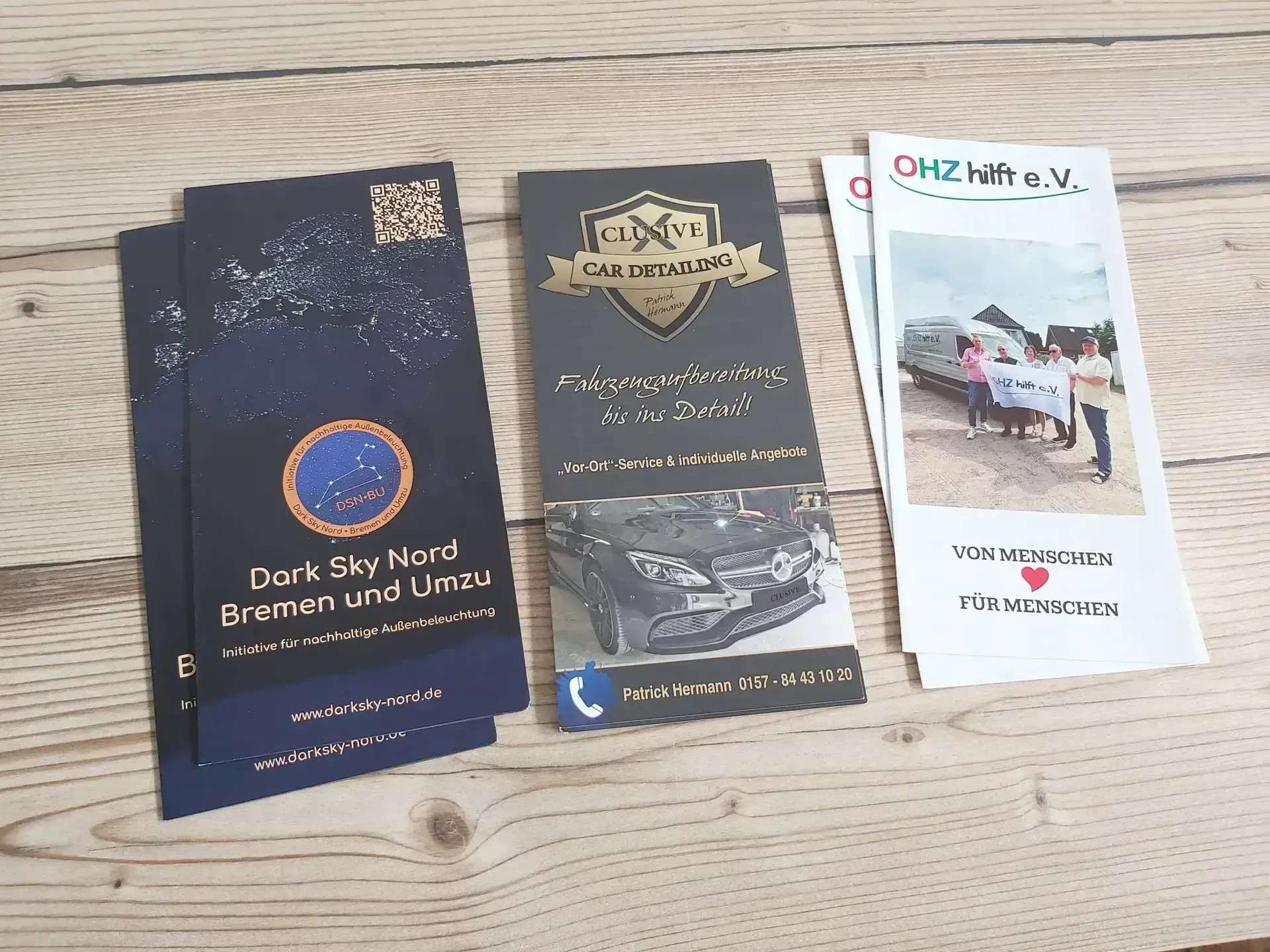 Flyer und Folder mit Firmendesign auf einem Holztisch