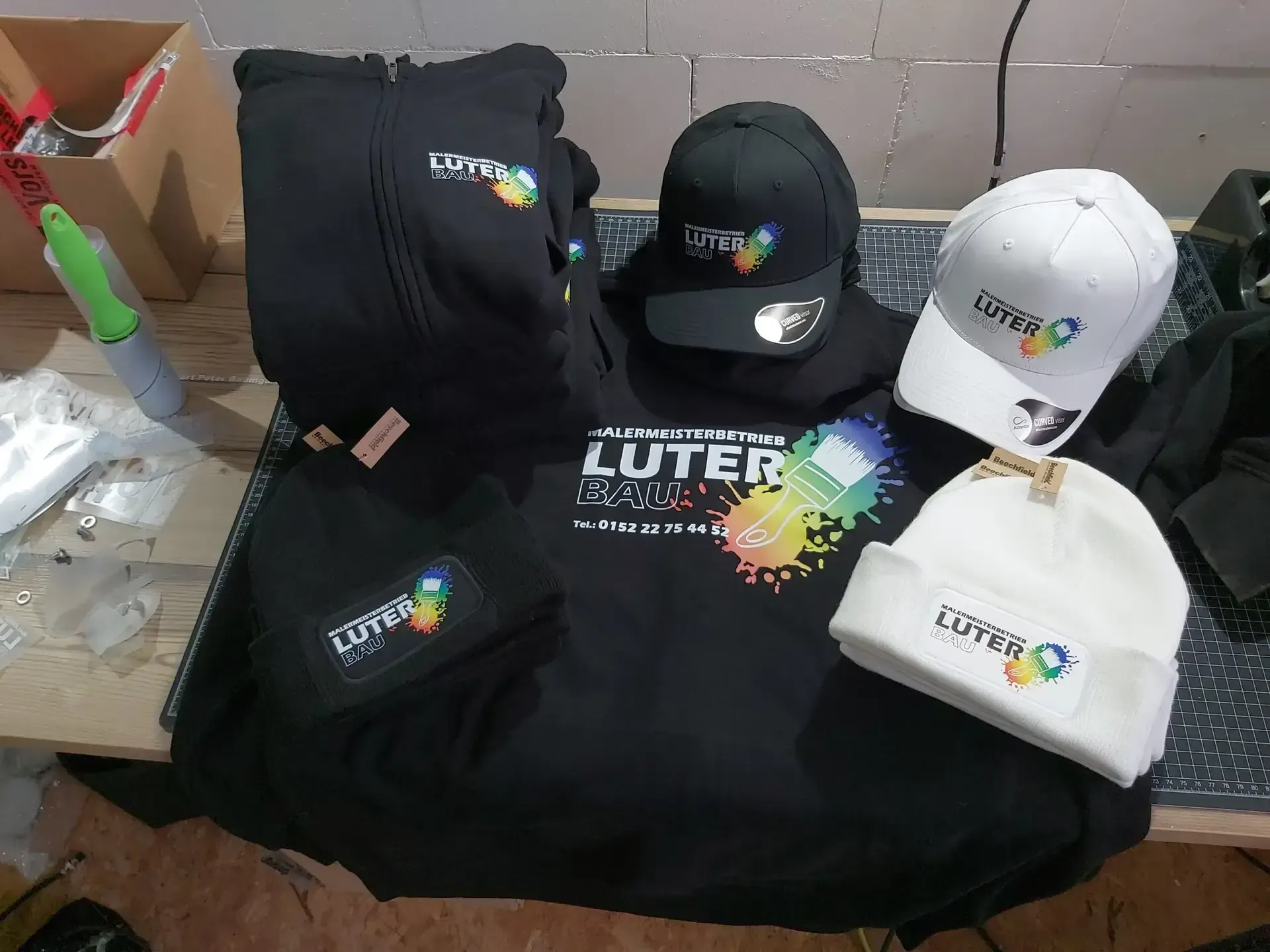 Kleidung und Mützen mit gesticktem Firmenlogo