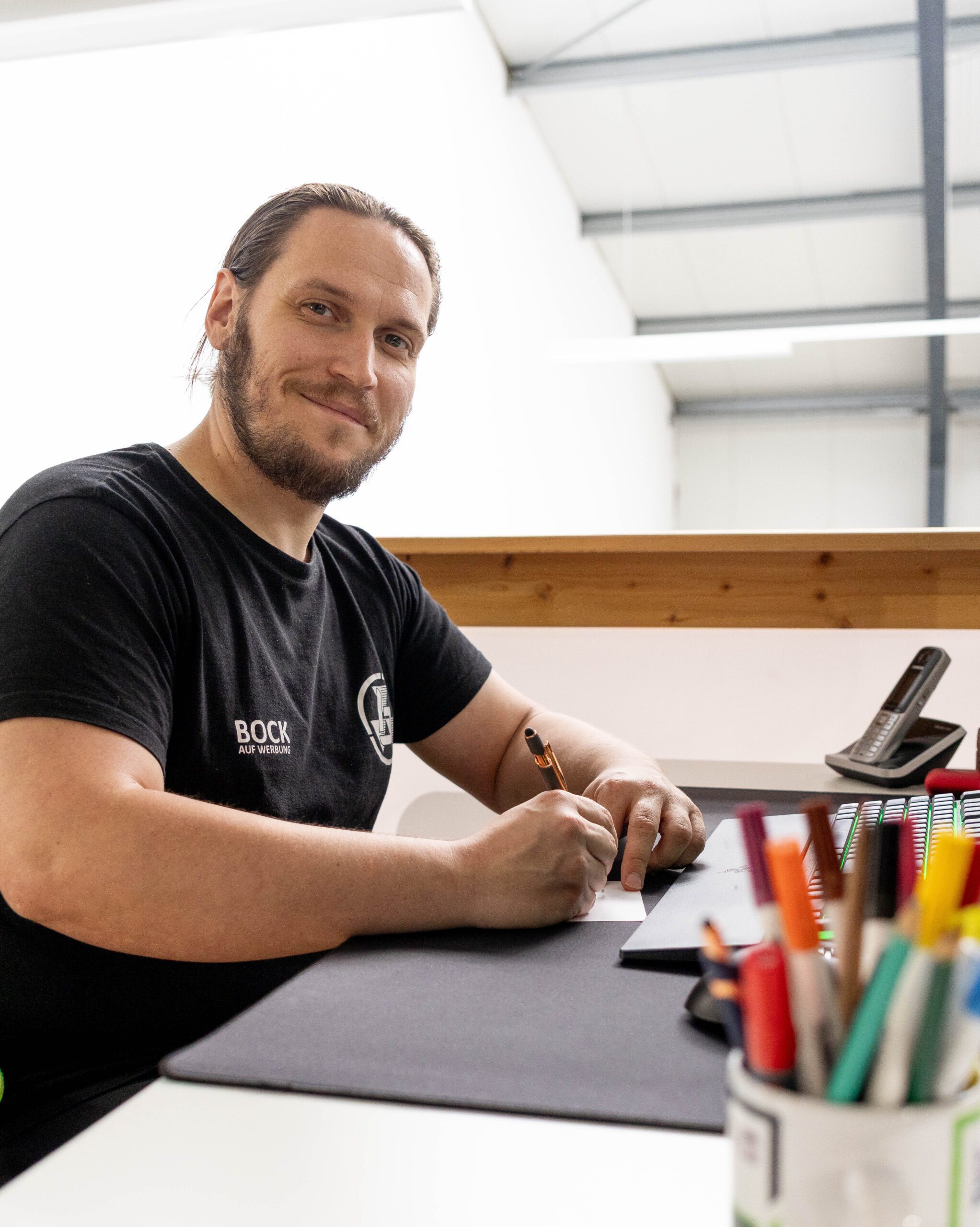 Sebastian Bock, Inhaber von buzzdesign, am Schreibtisch bei der Arbeit